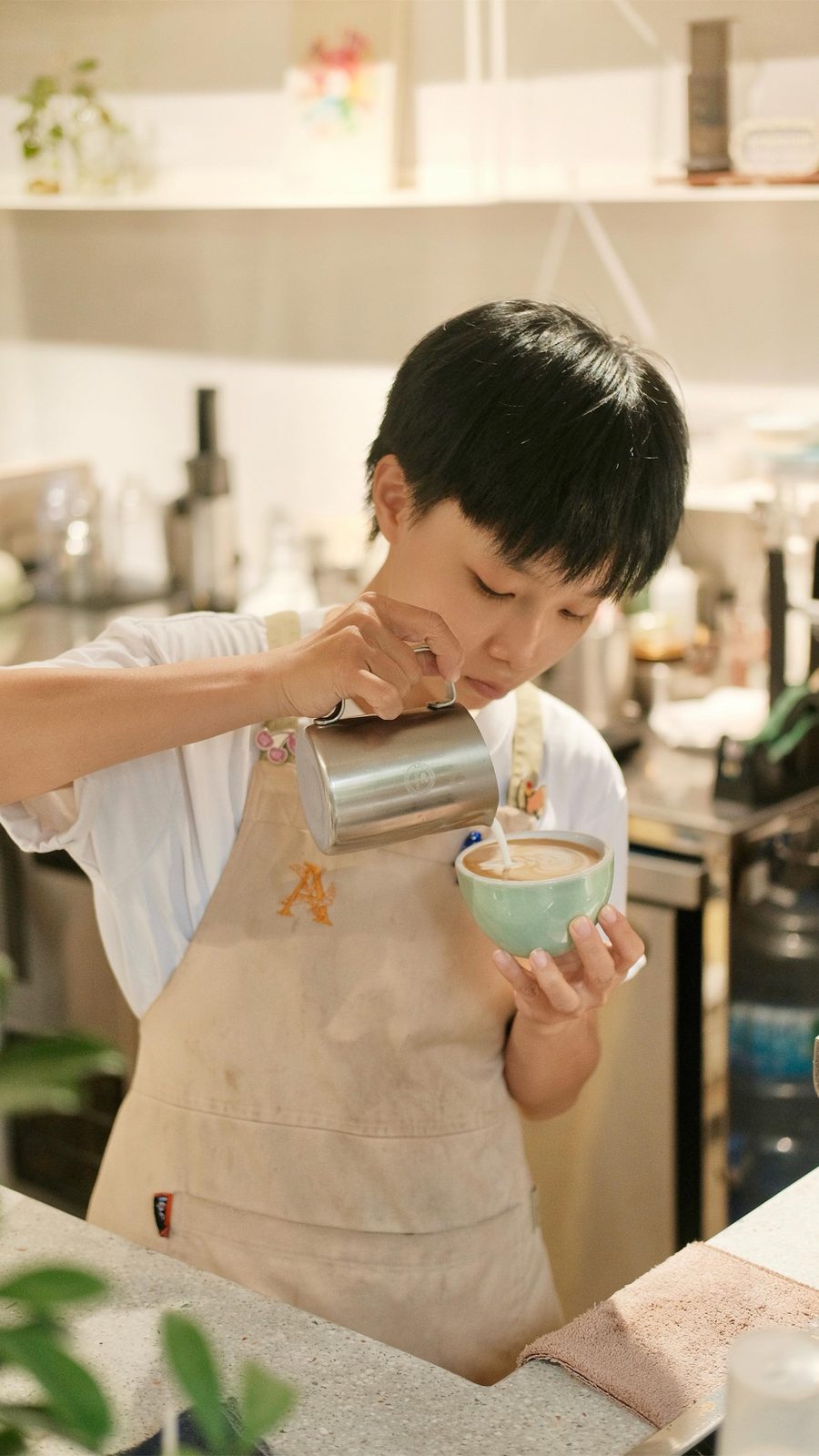 Barista đang rót tạo hình latte art lên mặt ly