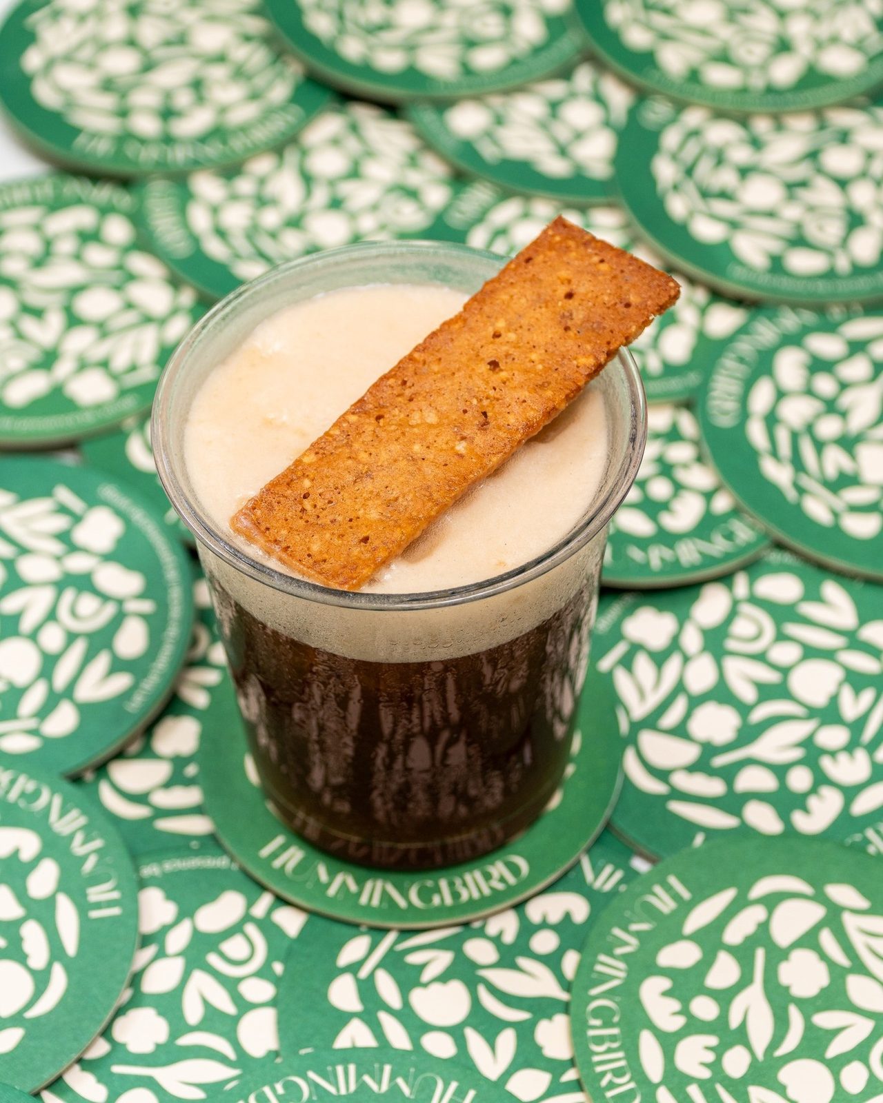 Ly nước đá kèm bánh cracker trên đế lót hoa văn xanh