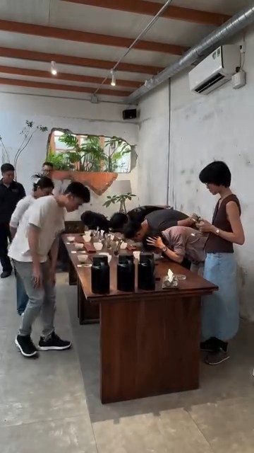 Buổi cupping cộng đồng quanh bàn gỗ