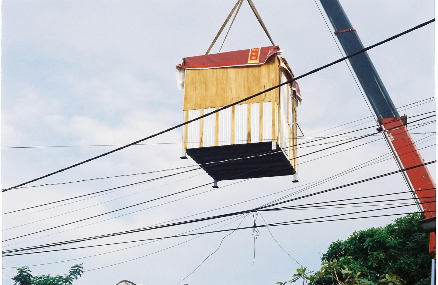 Cabin gỗ di động hoàn thiện, treo trên móc cẩu giữa quá trình vận chuyển